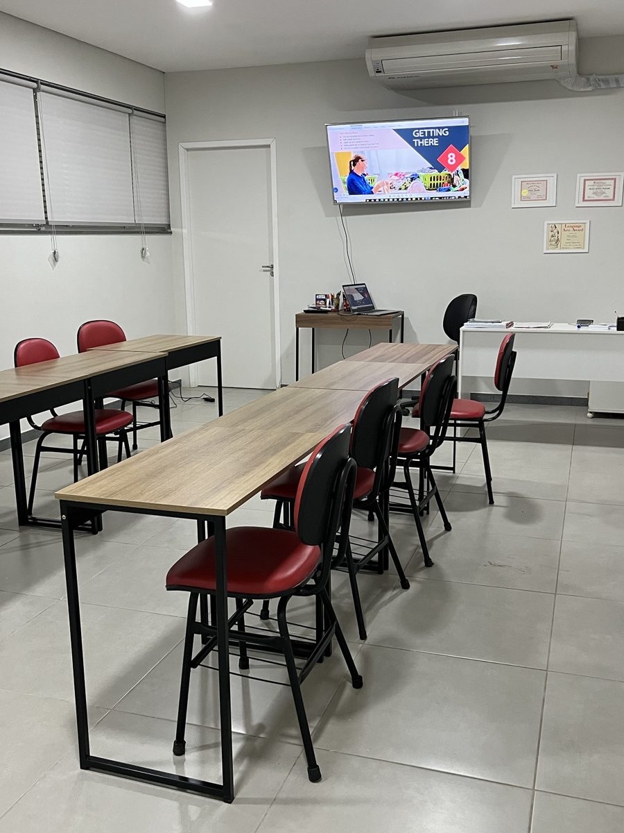 Sala de turmas com mesas, cadeiras e TV para as aulas